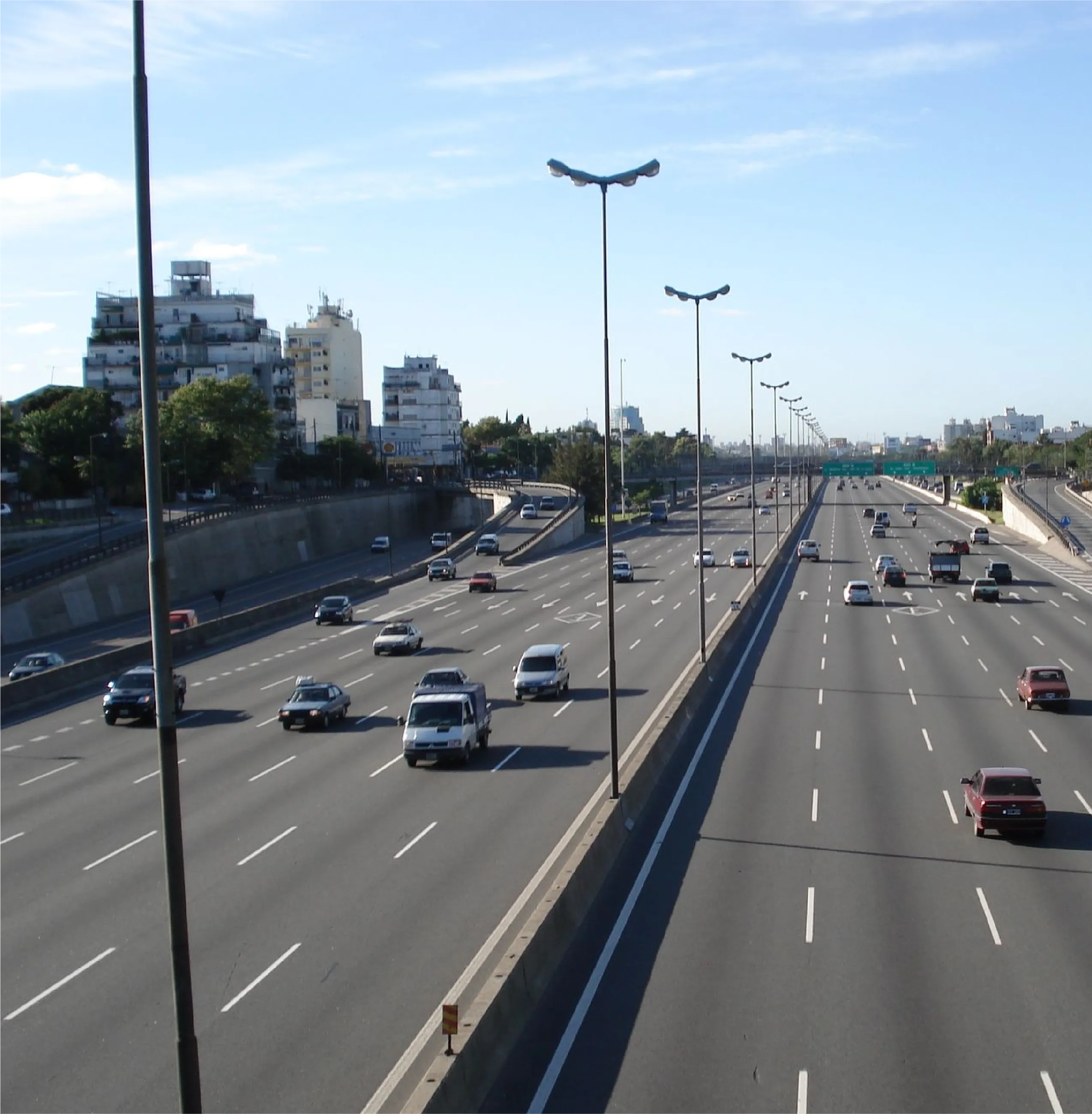 Autopista de varios carriles con tránsito, bordeada de edificios